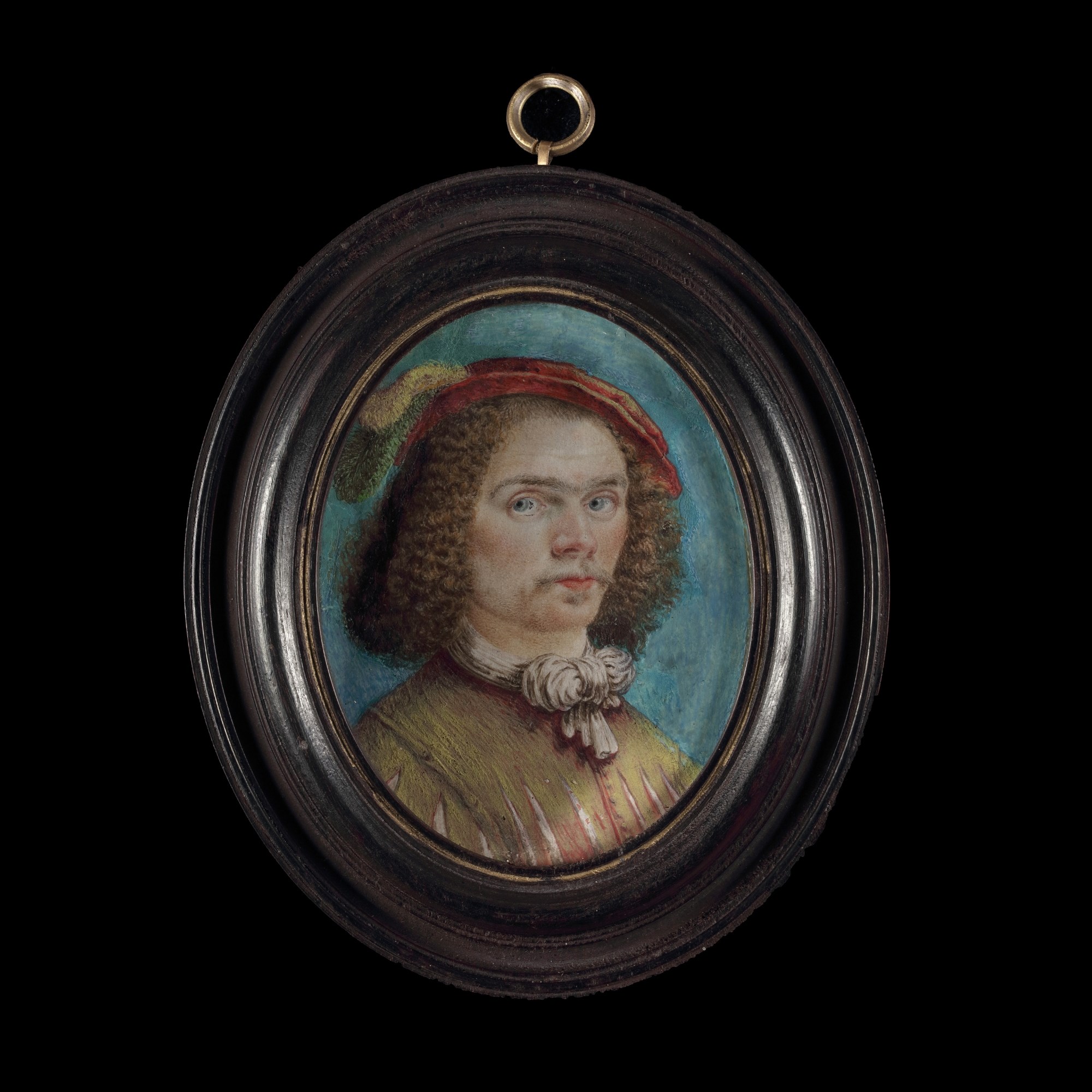 A portrait miniature of a Gentleman, wearing brown slashed doublet with tied neckscarf, a felt cap with green and white feathers on his curled hair